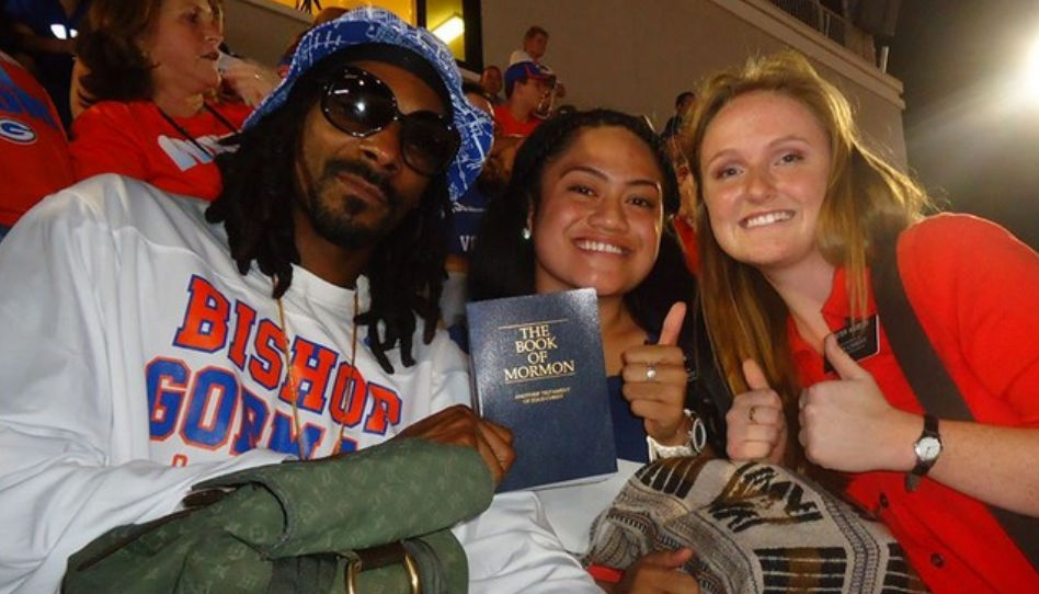 Ein Foto zweier Missionare, die dem Rapper Snoop Dogg ein Buch Mormon überreichen.