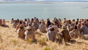 Zu sehen ist Jesus Christus, mit einer Menschenmenge, die ihm und seinen Lehren zuhören.