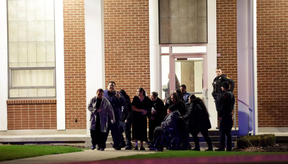 Menschen verlassen eine Trauerfeier, die durch eine Schießerei auf dem Parkplatz unterbrochen wurde.