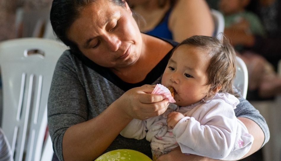 Eine Frau füttert ein Baby.