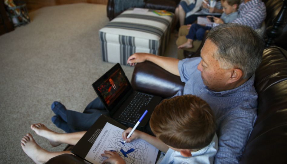 Ein Mann und sein Enkel verfolgen die Generalkonferenz.